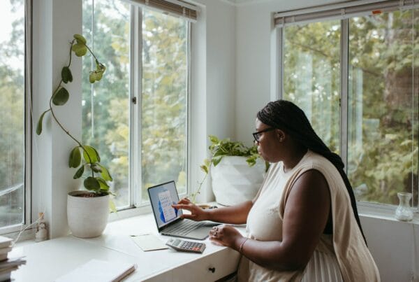 a woman sitting at a table with a laptop