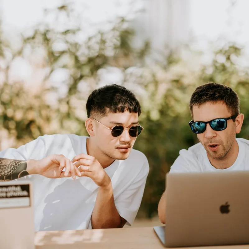 two men using MacBooks