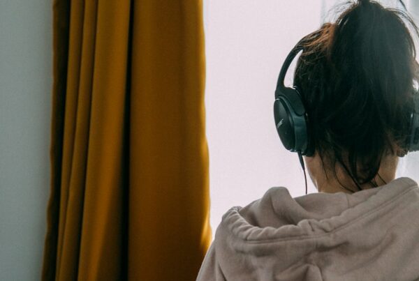 woman in gray shirt wearing black headphones