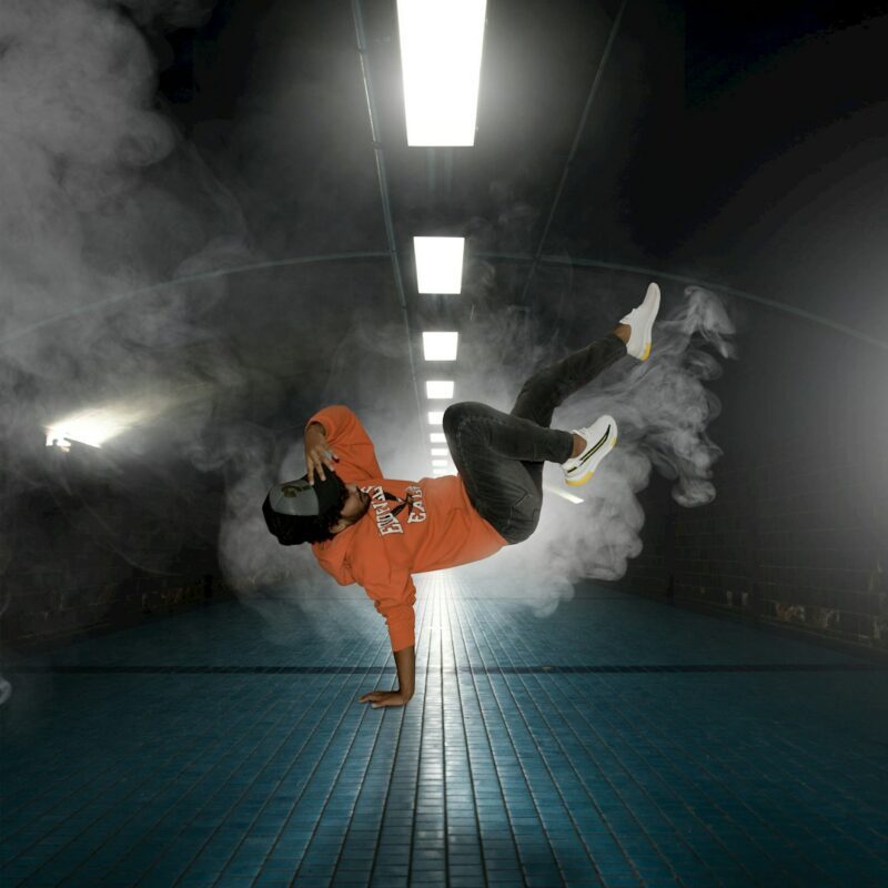 man in orange jacket and black pants