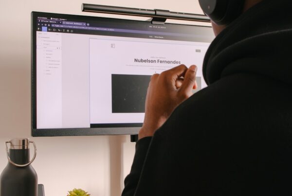 person in black hoodie sitting in front of black flat screen computer monitor