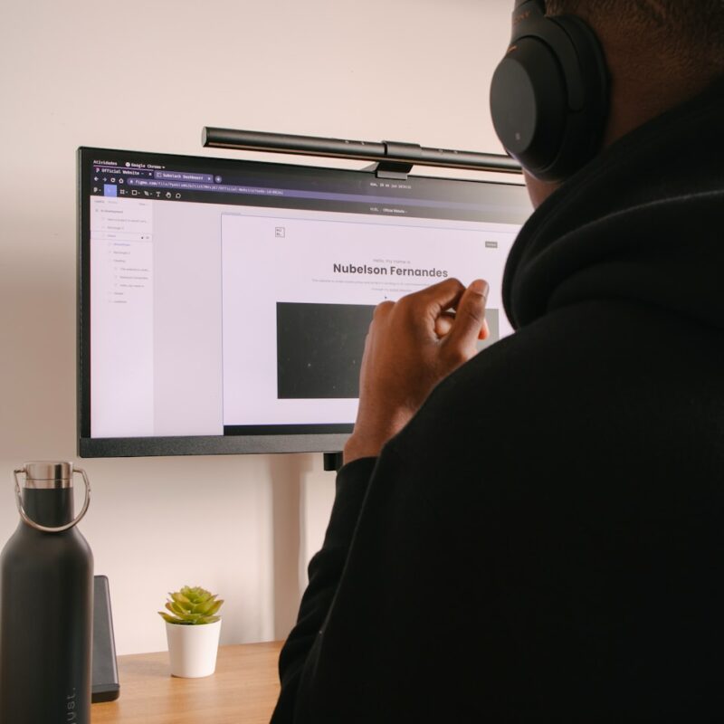 person in black hoodie sitting in front of black flat screen computer monitor